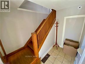 Hamilton apartment for rent - A wooden staircase with a white wall and a cardboard box on the floor.