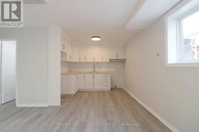 Toronto (Kensington-Chinatown) apartment for rent - A spacious kitchen with white cabinets and a window.