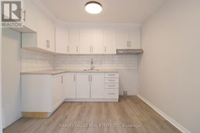 Toronto (Kensington-Chinatown) apartment for rent - A kitchen with white cabinets and a wooden floor.