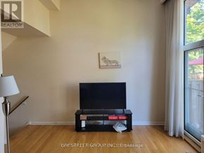 Toronto (Hillcrest Village) townhouse for rent - A black television sits on a wooden stand in a room with a painting on the wall.