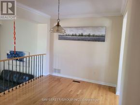 Toronto (Hillcrest Village) townhouse for rent - A living room with a black couch and a painting hanging on the wall.