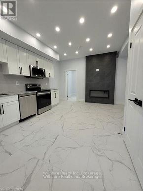 Tillsonburg multi-family for rent - A modern kitchen with a black oven and white cabinets.