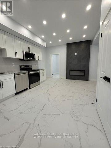 Tillsonburg multi-family for rent - A modern kitchen with a black oven and white cabinets.