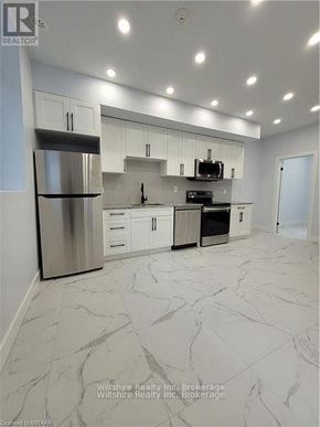 Tillsonburg multi-family for rent - A modern kitchen with a marble floor and stainless steel appliances.