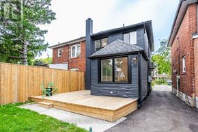 Toronto (Mount Dennis) apartment for rent - A modern house with a black exterior and a wooden deck.