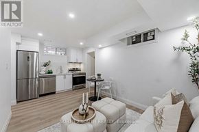 Toronto (Mount Dennis) apartment for rent - A modern kitchen with stainless steel appliances and a dining area with a round table and chairs.