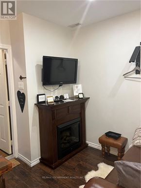 Hamilton (Dundas) apartment for rent - A living room with a fireplace and a flat screen TV mounted above it.