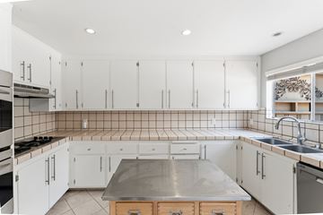 Oakland apartment for rent - A kitchen with white cabinets and a tile backsplash.