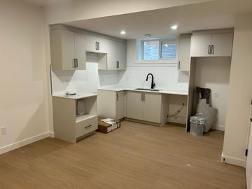 Edmonton apartment for rent - A kitchen with white cabinets and a window.