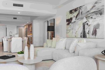 Bay Harbor Islands apartment for rent - A modern living room with white furniture and a large abstract painting on the wall.
