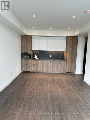 Kitchener condo for rent - A spacious kitchen with wooden cabinets and a black countertop.