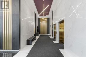 Ottawa condo for rent - A hallway with a marble floor and walls, and a bench on the left side.