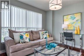 Toronto (Bayview Village) condo for rent - A living room with a couch, a painting, and a glass table.