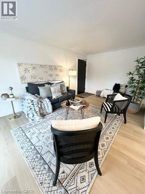 Kitchener apartment for rent - A living room with a black and white rug, a black chair, and a patterned sofa.