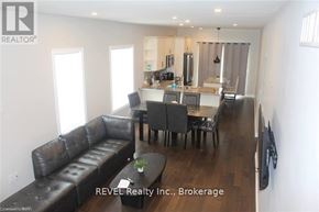 Welland (Lincoln/Crowland) apartment for rent - A living room with a black leather couch and a wooden floor.