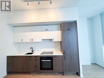 Toronto (Banbury-Don Mills) condo for rent - A kitchen with wooden cabinets and a black oven.