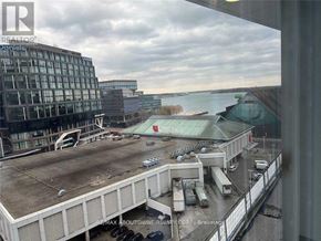 Toronto (Waterfront Communities) condo for rent - A view from a window of a parking lot and buildings.