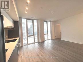 Toronto (Waterfront Communities) condo for rent - A spacious room with wooden floors and large windows.