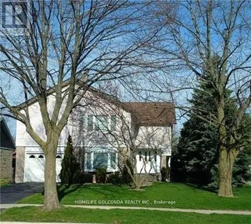 Mississauga (Erin Mills) apartment for rent - A white house with a brown roof and a tree in front.
