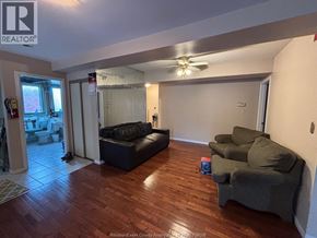 Windsor apartment for rent - A living room with a black couch and a ceiling fan.