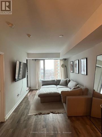 Ottawa condo for rent - A living room with a grey couch and a flat screen TV mounted on the wall.