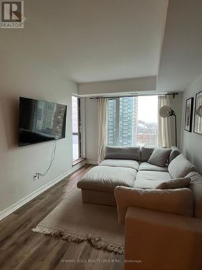 Ottawa condo for rent - A living room with a couch, a flat screen TV and a window with curtains.