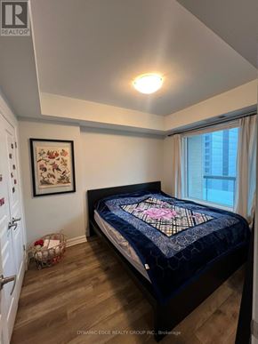 Ottawa condo for rent - A bedroom with a bed and a framed picture on the wall.