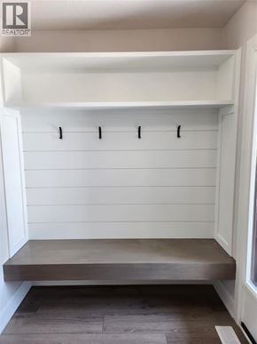 Plympton-Wyoming apartment for rent - A white mudroom with a bench and coat hooks.