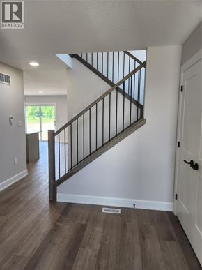 Plympton-Wyoming apartment for rent - A wooden staircase with a metal railing leads to a second floor.
