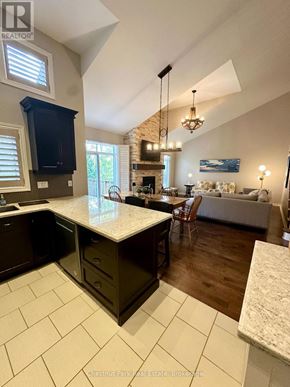 Collingwood townhouse for rent - A kitchen with a large island and a dining area with a table and chairs.