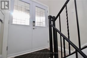 Ottawa apartment for rent - A white door with a glass window and a black railing.