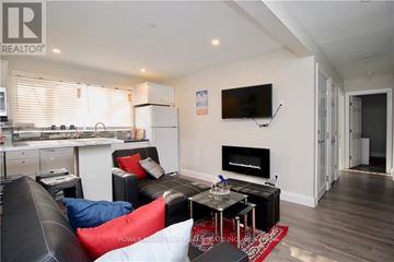 Ottawa apartment for rent - A living room with a black couch and a television mounted on the wall.