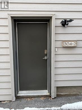 Ottawa apartment for rent - A grey door with a black handle and a number plate on the wall.
