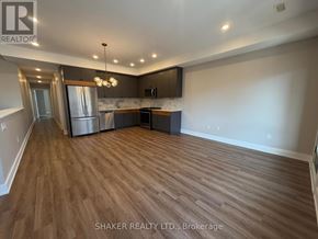 Ottawa apartment for rent - A spacious kitchen with wood flooring and a refrigerator.