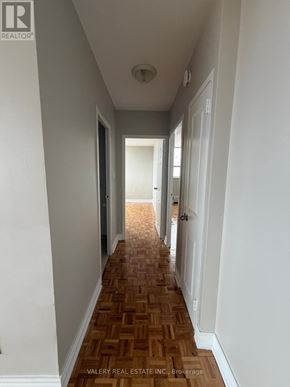 Toronto (Rockcliffe-Smythe) condo for rent - A long hallway with a wooden floor and white walls.