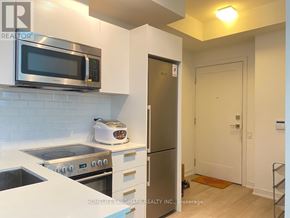 Toronto (Bay Street Corridor) condo for rent - A kitchen with a stove, microwave, and refrigerator.