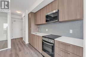 Toronto (Rouge) condo for rent - A kitchen with wooden cabinets and a black stove top oven.