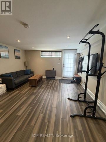 Toronto (Willowridge-Martingrove-Richview) apartment for rent - A living room with a black couch and a wooden coffee table.