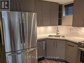 Toronto (Willowridge-Martingrove-Richview) apartment for rent - A kitchen with a stainless steel refrigerator and cabinets.