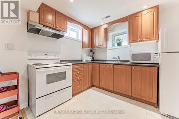 Richmond Hill (Devonsleigh) apartment for rent - A kitchen with wooden cabinets and white appliances.