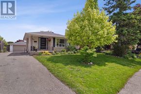 Halton Hills (Georgetown) apartment for rent - A house with a driveway and a tree in front of it.