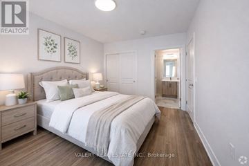 Waterloo condo for rent - A living room with a grey couch and a window overlooking a parking lot.