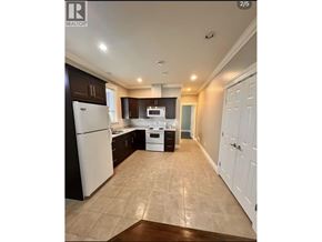 Richmond apartment for rent - A kitchen with white appliances and brown cabinets.