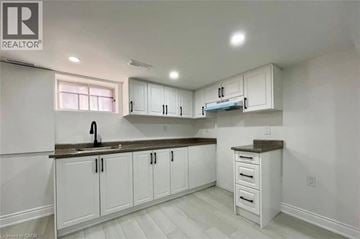Hamilton apartment for rent - A kitchen with white cabinets and a brown countertop.