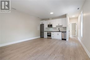 Hamilton (Raleigh) apartment for rent - A well-lit, empty kitchen with white cabinets and a wooden floor.