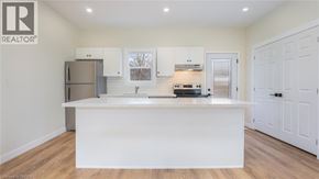 Brantford townhouse for rent - A white kitchen with a wooden floor and white cabinets.