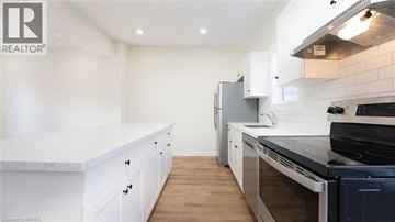 Brantford townhouse for rent - A modern kitchen with white cabinets and a black stove top.