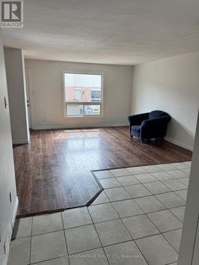 London East (East I) townhouse for rent - A room with a large window and a wooden floor.