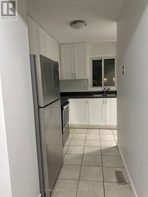 London East (East I) townhouse for rent - A kitchen with white cabinets and a stainless steel refrigerator.