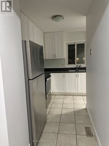 London East (East I) townhouse for rent - A kitchen with white cabinets and a stainless steel refrigerator.
